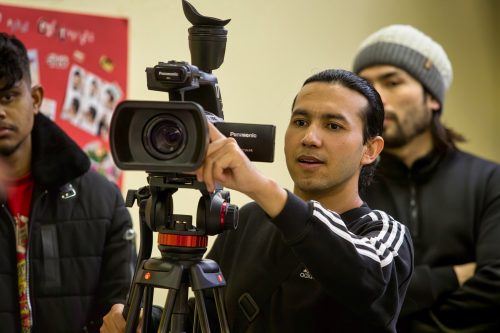 Foto von einem jungen erwachsenem, der hinter einer Kamera steht
